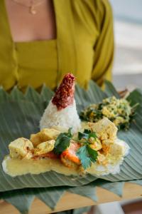 a plate of food with rice and vegetables on it at Ashyana Candidasa Beach Resort in Candidasa