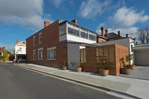 a large brick house on the side of a street at The Lollyshop Apartment in Battery Point in Hobart