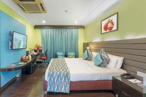 a hotel room with a bed and a desk at Indismart Hotel in Kolkata