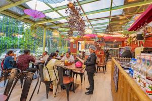 a group of people sitting at tables in a restaurant at Indismart Hotel in Kolkata