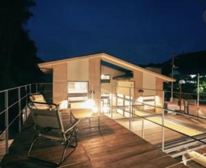 a deck with two chairs on it at night at ODEON Gongen松山市一組限定貸切グランピング in Horiechō