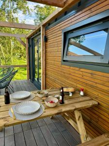 a picnic table on a deck with plates of food at TinyHouse Noorderlicht in Haastrecht +6 photos