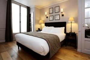 a bedroom with a large bed and two windows at Hotel Saint-Louis Pigalle in Paris