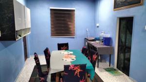 a blue room with a table and chairs and a sink at Faridd homestay in Kampung Titi Tampang