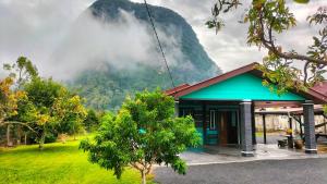 a small building with a mountain in the background at Faridd homestay in Kampung Titi Tampang