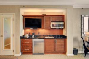 a kitchen with wooden cabinets and a sink and a microwave at MGM Studio Suite with POOL VIEW Tower 1 in Las Vegas