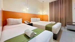 Ένα ή περισσότερα κρεβάτια σε δωμάτιο στο Travelbee Capitol Inn