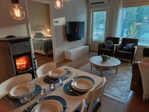 a living room with a table and a living room with a fireplace at Kaisantien Kirsti, Vuokatti in Vuokatti