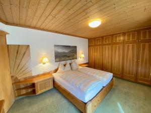 una camera da letto con un letto grande con soffitto in legno di Pension Gabi a Saalbach Hinterglemm