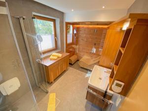 un bagno con doccia e lavandino di Pension Gabi a Saalbach Hinterglemm