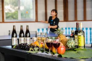 a table with bottles and glasses of wine and fruit at 貸別荘TANoSHI-SA- in Jahana
