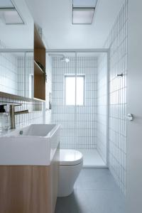 a white bathroom with a toilet and a sink at Cosy Riverside Escape with River Views in Inveresk