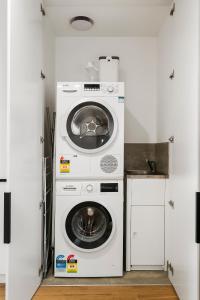 a washing machine and a dryer in a kitchen at Stylish and Modern 2BR w King Bed, Study and Car Park in Carnegie