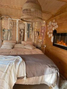 a bedroom with two beds and a fire place at Cabane Coco bohème in Azereix