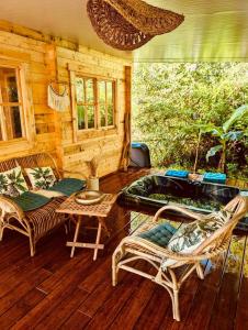 veranda di una baita di tronchi con vasca idromassaggio di Cabane Coco bohème a Azereix