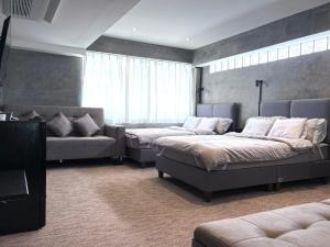 ein Schlafzimmer mit zwei Betten und einer Couch in der Unterkunft Nonoteru Chiangmai in Chiang Mai