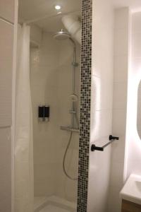 a bathroom with a shower with a glass door at L'escapade, entièrement rénové, proche centre in Grenoble