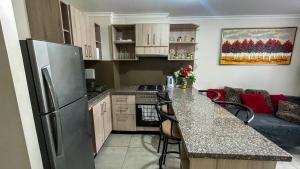 une cuisine avec un réfrigérateur et un plan de travail dans l'établissement Departamento Jardines del Pacifico, à La Serena