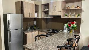 une cuisine avec un réfrigérateur et des armoires en acier inoxydable dans l'établissement Departamento Jardines del Pacifico, à La Serena