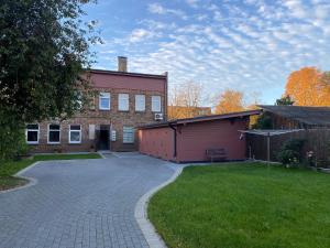 a brick building with a garage and a driveway at Karla iela in Ventspils