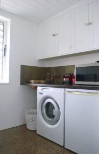 a kitchen with a washing machine and a microwave at The Eagle's Nest in Manilla