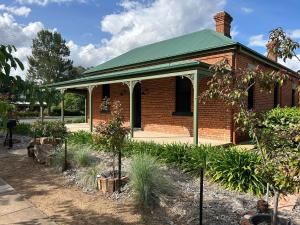 a brick house with a green roof and some plants at The Eagle's Nest in Manilla