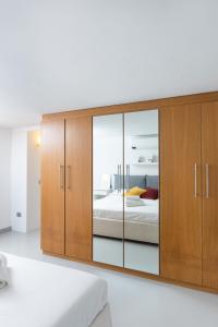 a bedroom with a large wooden cabinet with mirrors at White and Brown Exclusive Loft With Terrace - Free Parking - M2 station in Milan