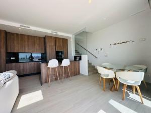 a living room with a glass table and white chairs at Villa Finestrat Benidorm Golf y Playa in Cala de Finestrat