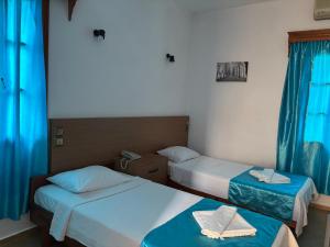 two beds in a small room with blue curtains at Ali Baba Hotel Gümbet in Gümbet +54 photos
