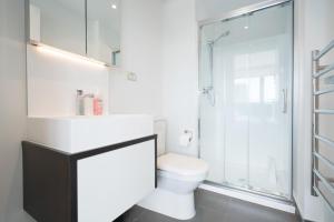 a white bathroom with a toilet and a shower at Amazing Skytower View 2 Bedroom 2 bathroom Apartment in Auckland
