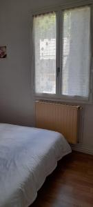 a bedroom with a bed and a large window at Appartement Bagnères-de-Luchon T2 nuitée-semaines in Luchon +3 photos