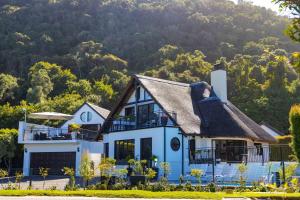 a house with a thatched roof at Cloverleigh Guest House in Wilderness