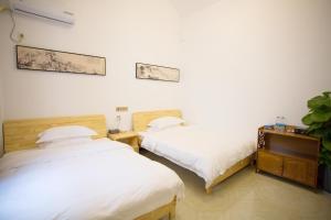 Postel nebo postele na pokoji v ubytování 建水县井宿客栈