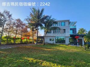 una casa con una palmera delante en Najima B&B, en Jian