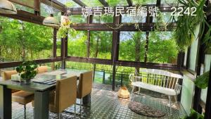 un porche cubierto con mesa y sillas en Najima B&B, en Jian