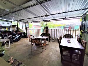 an outdoor patio with tables and chairs and motorcycles at D-Rima Homestay Ruteng in Ruteng