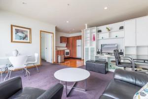 a living room with a couch and a table at Seaview Waterfront Hotel Apt in Auckland