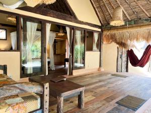 a room with a bed and a table and windows at Gili Asahan Eco Lodge & Restaurant in Gili Asahan +37 photos