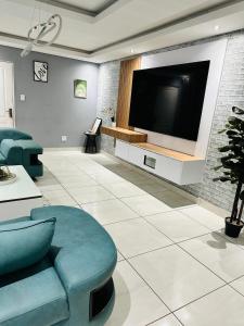 een woonkamer met een flatscreen-tv aan de muur bij West Home Rest in Westonaria