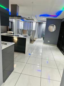 een keuken met witte tegelvloeren en een keuken met blauwe lichten bij West Home Rest in Westonaria