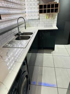 een keuken met een spoelbak en een wasmachine bij West Home Rest in Westonaria