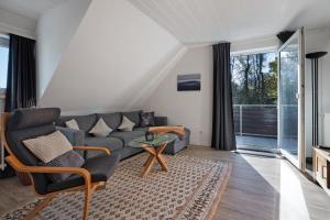 a living room with a couch and a table at Fewo Harzwichtel am Waldesrand in Braunlage