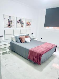 a bedroom with a large bed with a lamp and a table at Apartamento Aljaralto Sevilla in San Juan de Aznalfarache