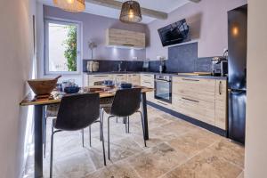a kitchen with a wooden table and chairs in it at Les Jasmins en Provence in L'Isle-sur-la-Sorgue
