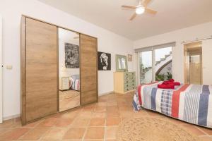 a bedroom with a bed and a large wooden closet at Flamenco Soul in Chiclana de la Frontera