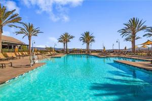 a large swimming pool with chairs and palm trees at Dreamy Bloom Enclave Irivne LA RMV in American Display Heliport