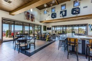 a restaurant with tables and chairs and windows at Dreamy Bloom Enclave Irivne LA RMV in American Display Heliport