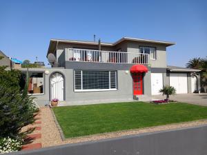 斯瓦科普蒙德19 Richthofen的一座带红色门和绿色庭院的房子