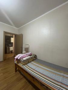a bed sitting in a room next to a wall at Fully furnished, 1-bedroom apartment in Ulaanbaatar