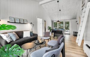 a living room with a couch and a piano at Amazing Home In Væggerløse With Sauna in Marielyst